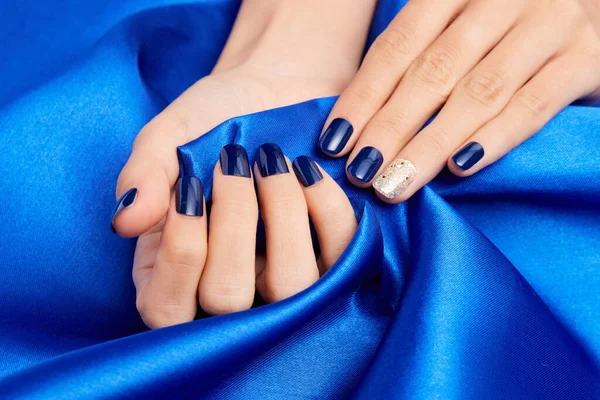 Belas Mãos Femininas Com Unhas Azuis Segurando Tecido Cetim Azul — Fotografia de Stock