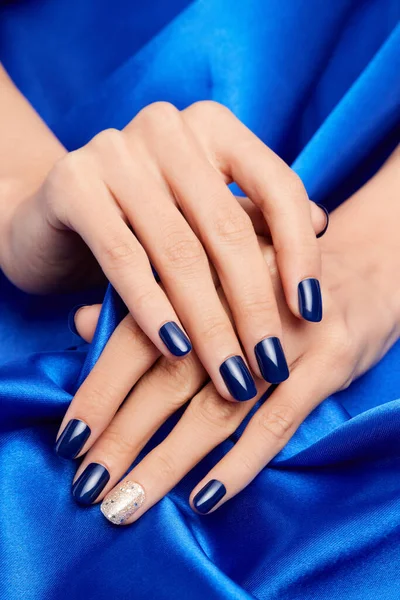 Belas Mãos Femininas Com Unhas Azuis Segurando Tecido Cetim Azul — Fotografia de Stock