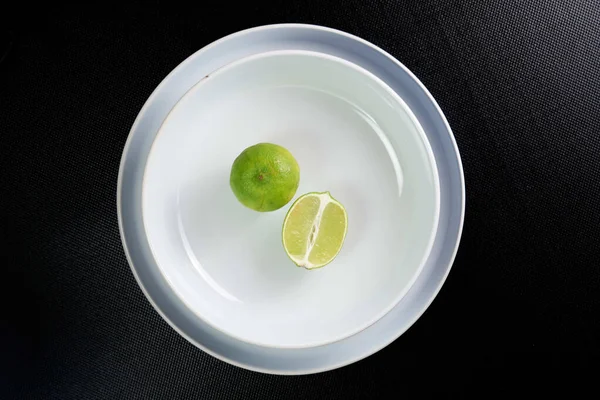 Lime Slice White Plate Black Background — Stock Photo, Image