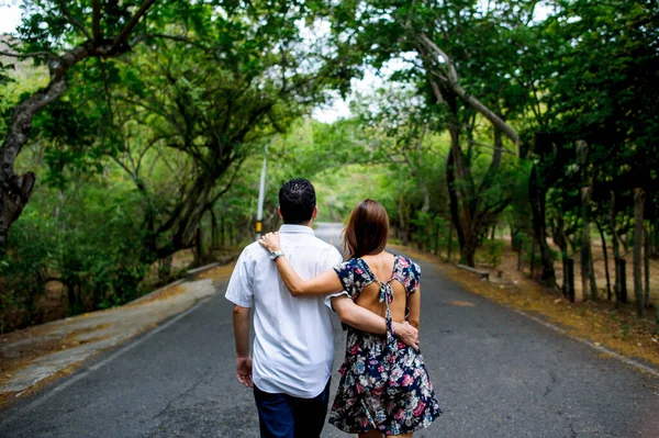 夏の公園の通りを歩くのが好きな若いカップルのバックビュー — ストック写真