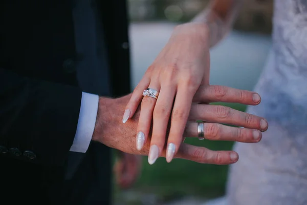 新娘和新郎手拿着结婚戒指的特写镜头 — 图库照片