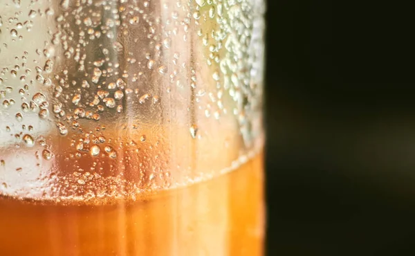 stock image A closeup of the waterdrops on the surface of the glass filled with orange juice