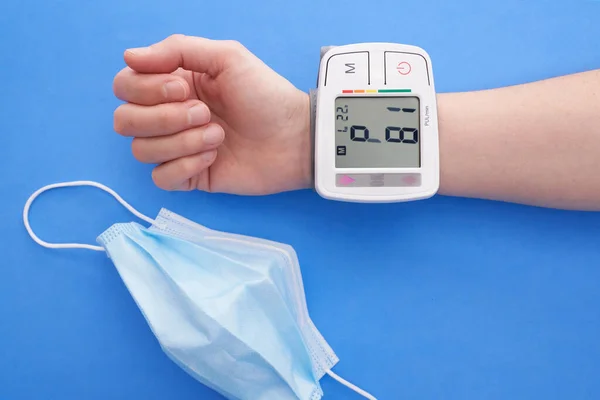 Eine Person Misst Ihren Blutdruck Mit Einem Blutdruckmessgerät Auf Blauem — Stockfoto