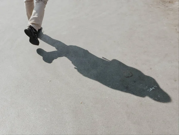 一个人走在沥青路面上的影子 — 图库照片