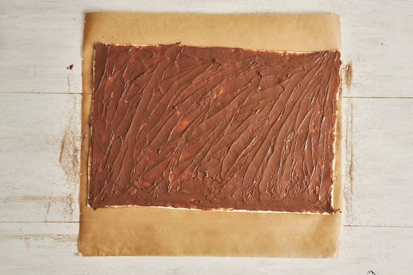 Μια Κορυφαία Άποψη Κρεμώδους Σοκολάτας Απλωμένο Μια Περγαμηνή Ppaper Στο — Φωτογραφία Αρχείου