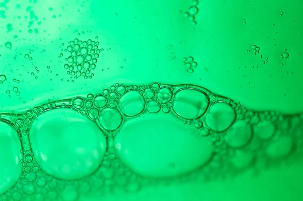 绿色背景上肥皂泡的宏观镜头 — 图库照片