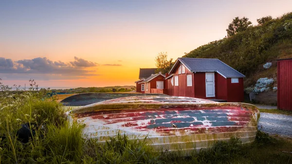 Fascinující Záběr Červených Dřevěných Domů Barevných Lodí Pozadí Západu Slunce — Stock fotografie