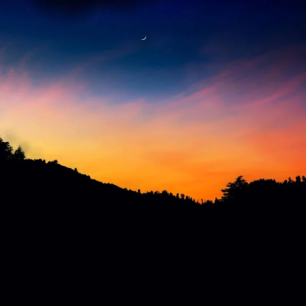 Eine Landschaft Mit Der Silhouette Von Bäumen Und Hügeln Während — Stockfoto