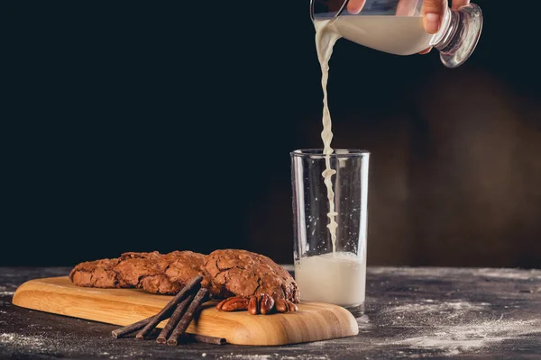 Närbild Färska Pekannkakor Och Ett Glas Mjölk Som Hälls — Stockfoto