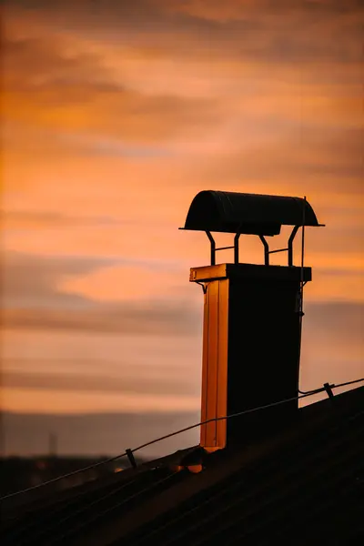 Pionowe Ujęcie Komina Domu Uchwyconego Podczas Barwnego Zachodu Słońca — Zdjęcie stockowe