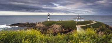 A panoramic view of Isla Pancha island lighthouse on the coast of Ribadeo, Galicia, Spain clipart