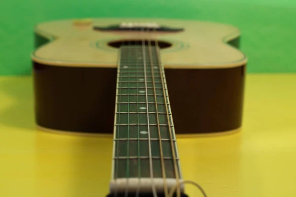 Zbliżenie Ujęcie Gitary Żółtym Zielonym Tle — Zdjęcie stockowe