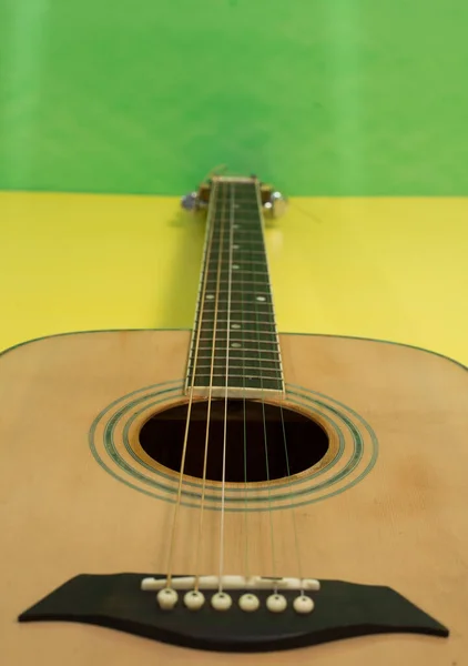 Pionowe Ujęcie Gitary Żółtym Zielonym Tle — Zdjęcie stockowe