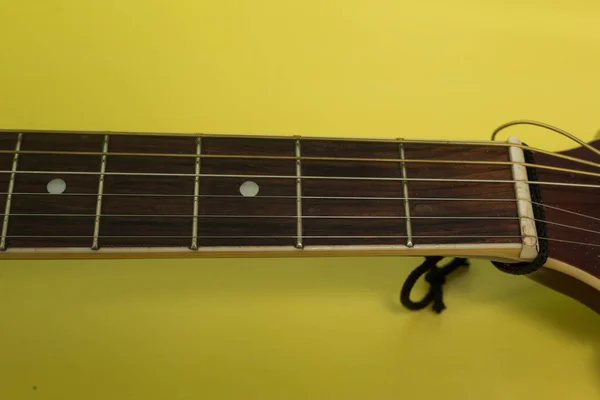 黄色い背景のギターネック — ストック写真