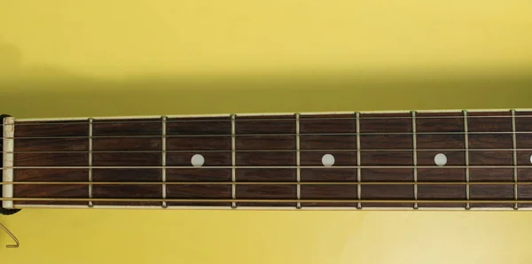 Sarı Arka Planda Bir Gitar Yakası — Stok fotoğraf