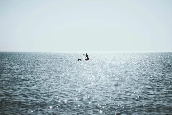蘇の下でシーカヤックを漕いでいる孤独な人 — ストック写真