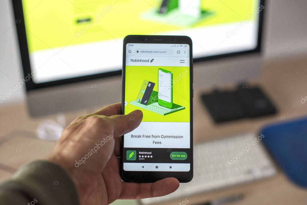 MADRID, SPAIN - Jan 31, 2021: A man checking in his smartphone the website of Robinhood that is an app for stock trading brokers.