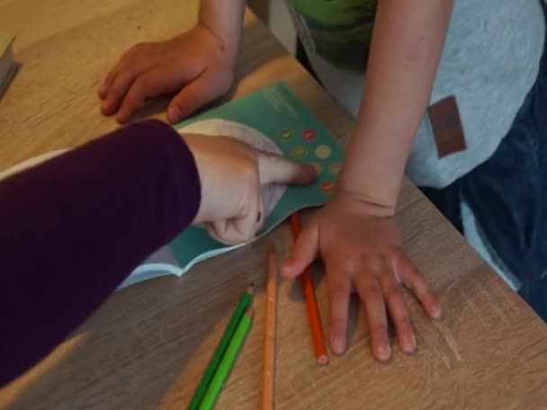 Νεαρό Αγόρι Χρησιμοποιώντας Πολύχρωμα Μολύβια Για Χρωματίσετε Σελίδες Από Ένα — Αρχείο Βίντεο
