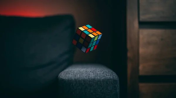 Una Messa Fuoco Selettiva Cubo Rubik Nell Aria Sopra Divano — Foto Stock