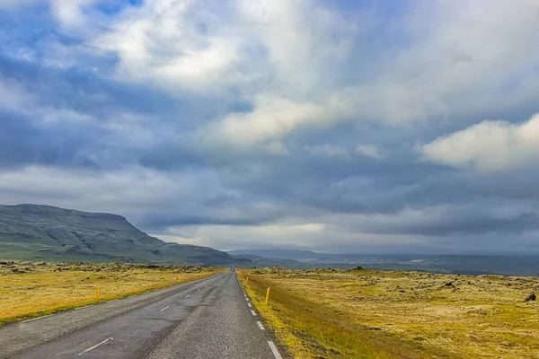 아이슬란드의 구름낀 언덕과 밭으로 둘러싸인 도로의 — 스톡 사진
