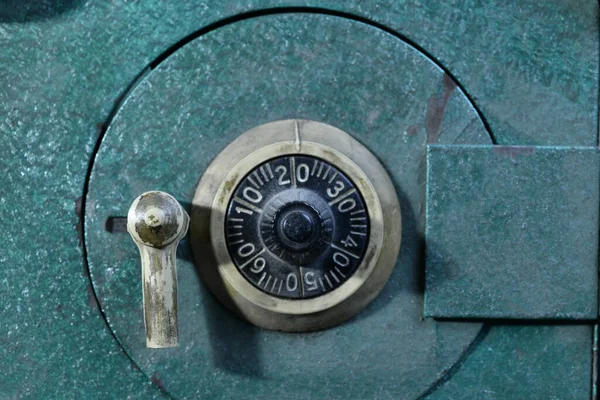 A closeup of the rotary combination lock of a vintage safe deposit box