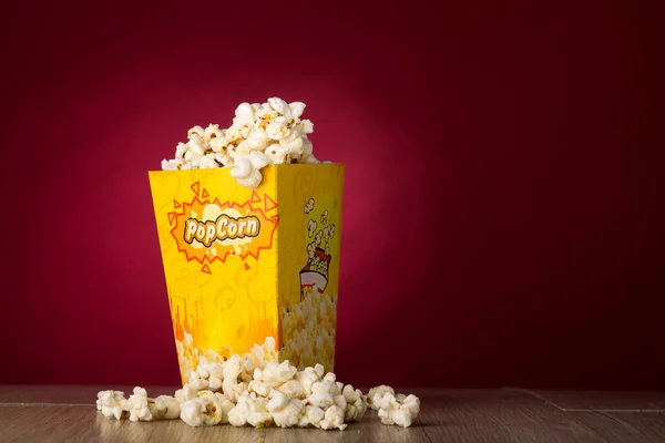 Eine Nahaufnahme Von Popcorn Auf Dem Tisch Mit Dunkelrotem Hintergrund — Stockfoto