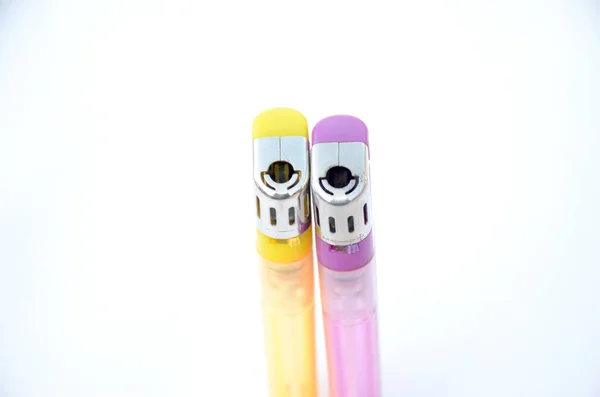 白色背景上隔离的一对黄色和紫色气体打火机 — 图库照片