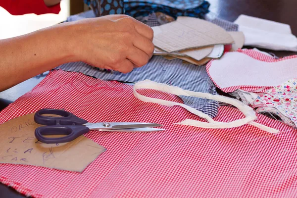 A seamstress making cloth masks for facial protection