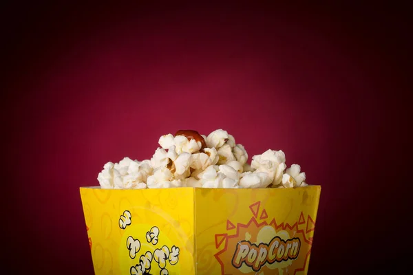 Eine Nahaufnahme Von Leckerem Popcorn Mit Dunkelrotem Hintergrund — Stockfoto