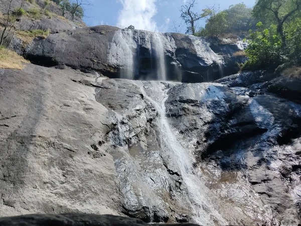 Nízký Úhel Vodopádu Stékajícího Skal Třpytících Pod Zamračenou Modrou Oblohou — Stock fotografie