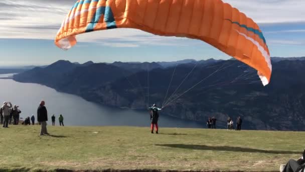 Ein Gleitschirmflieger Startet Seinen Flug Gardasee Die Menschen Stehen Daneben — Stockvideo
