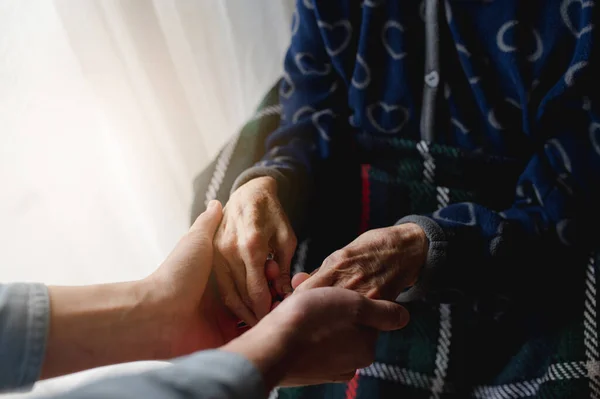 Een Zorgzame Kleinzoon Die Oma Handen Vasthoudt — Stockfoto