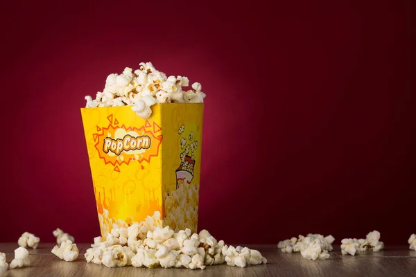 Eine Nahaufnahme Von Popcorn Auf Dem Tisch Mit Rotem Hintergrund — Stockfoto