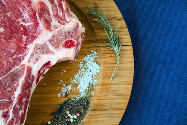 ローズマリーなどのスパイスを加えたテーブルの上に生の牛肉の肉のスライス リブアイステーキの成分 — ストック写真