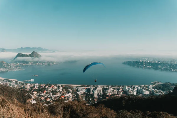 ブラジルのそれらの上にパラグライダーと建物や丘に囲まれた海の高角度ビュー — ストック写真