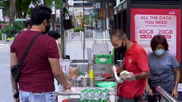 象徴的なシンガポールのアイスクリームサンドイッチを販売しているおじさん パンのスライスに包まれたアイスクリーム シンガポールのオーチャードロード — ストック動画