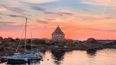 A mesmerizing shot of Christiansoe island, Bornholm Denmark with boats at a beautiful sunset background clipart