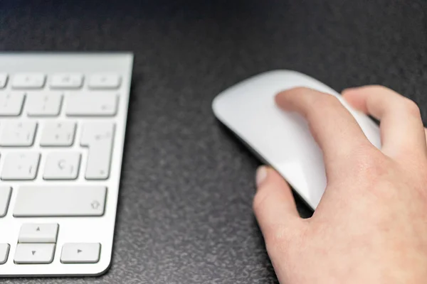 Tiro Foco Seletivo Uma Mão Segurando Mouse Branco Lado Teclado — Fotografia de Stock