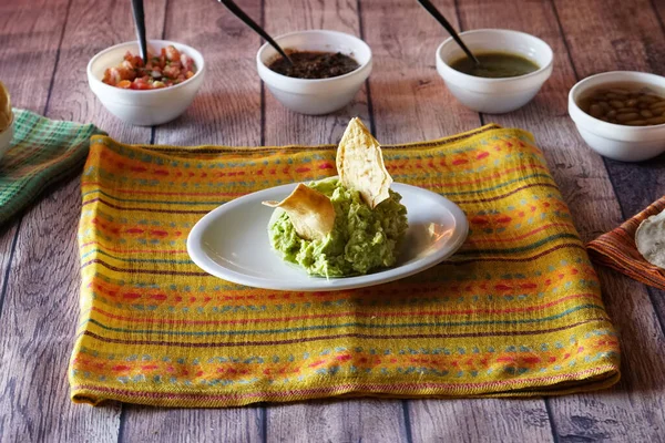 Closeup Shot Guacamole Chips Wooden Table Colorful Tablecloth — Stock Photo, Image