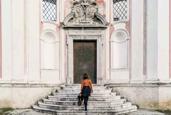 一个女旅行家走在一座旧建筑的楼梯上的背景图 — 图库照片