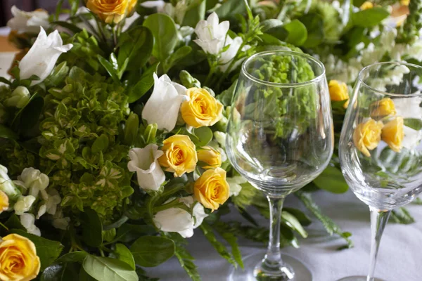 Egy Közelkép Borospoharakról Asztalon Lévő Virágok Előtt Ünnepi Belsőépítészet — Stock Fotó