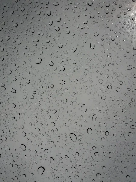 Eine Vertikale Aufnahme Von Regentropfen Auf Grauem Hintergrund — Stockfoto