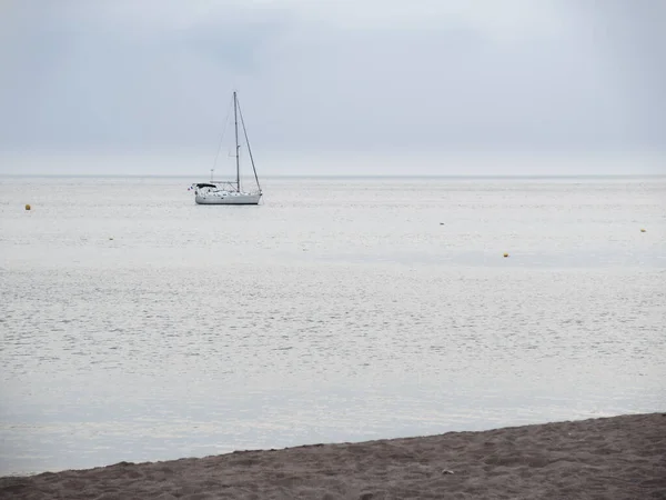 曇りの日に浜辺から捕獲された穏やかな海の中のボート — ストック写真