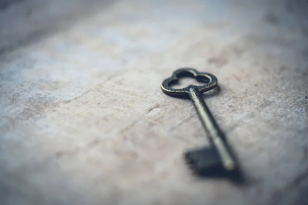 A closeup of an antique key on a wooden surface