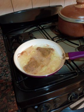 Frying a traditional tasty tender homemade breaded veal meat cutlet Milanese schnitzel in a nonstick pan. High angle shot. clipart