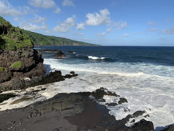 夏威夷毛伊岛的海洋景观 波浪在黑色火山岩和明亮的热带植物上飞溅 — 图库照片