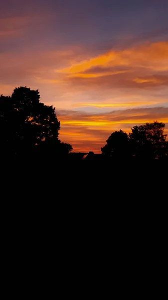 Pionowy Zachód Słońca Pomarańczowym Zachodem Słońca Chmurami Przodu Znajduje Się — Zdjęcie stockowe