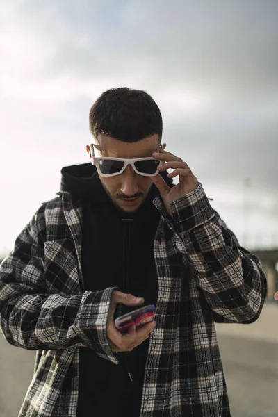 Colpo Verticale Bel Maschio Elegante Occhiali Sole Guardando Suo Telefono — Foto Stock