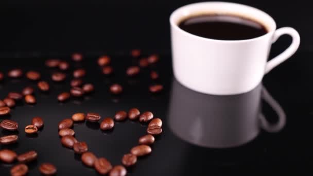 Šálek Kávy Černými Hnědými Kávovými Zrny Podobě Srdce Tmavém Pozadí — Stock video
