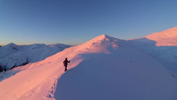 Ung Man Vandrar Toppen Ett Snöigt Berg Vid Vacker Vintersolnedgång — Stockvideo